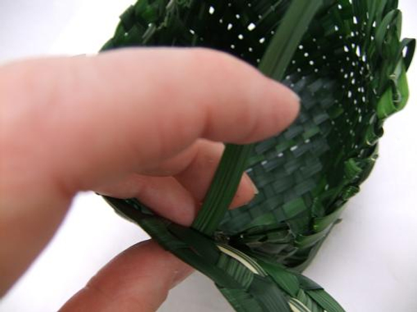 Stitch the first band around the rugged top rim of the basket with grass.