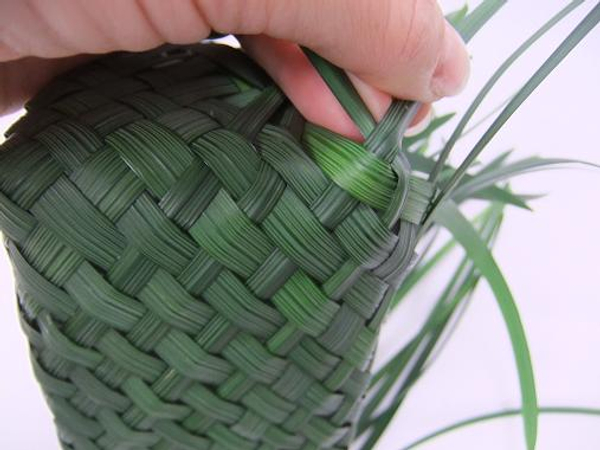 To weave the sides create a sharp corner by folding and weaving the grass.