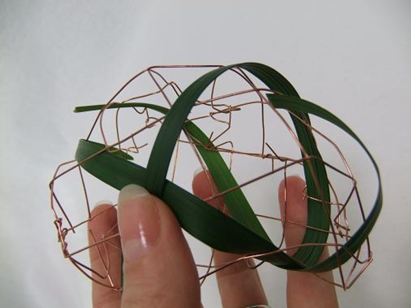 Continue to weave the grass through the biodegradable copper mesh.