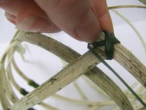 Cut a short section of cane and tie to the basket frame.