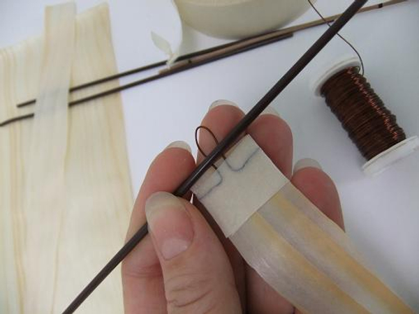 Measure the hook wire so that it can easily fit over the wire you want to hang the paper from.