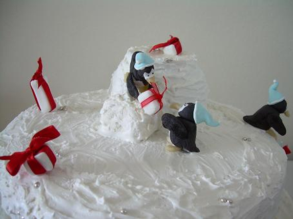 Fondant penguins stacking gifts.