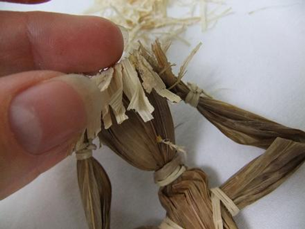 Glue snippets of raffia for hair.