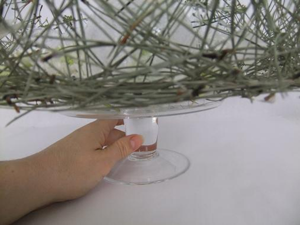 Place the Piled Pine Needle Tabletop Wreath on a glass cake stand.