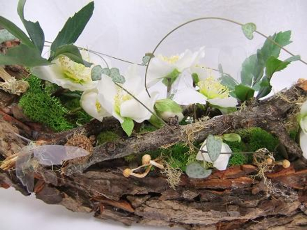 Again Reindeer moss, Hellebore flowers, Lichen covered twigs, Rosary vine and dried mushrooms decorate the design