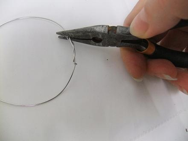 Cut the wire shorter and crimp it flat with pliers