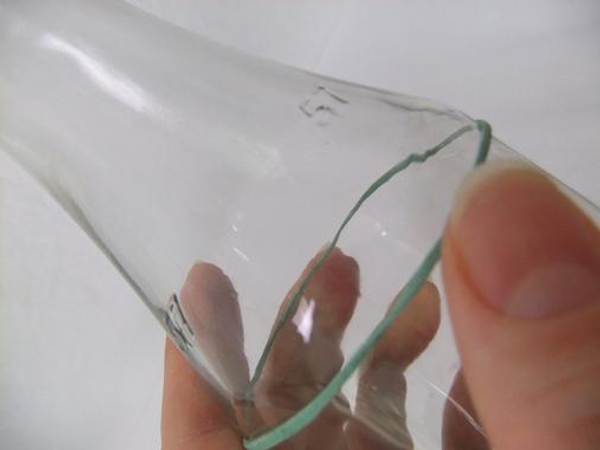 Place an elastic band around a glass bottle