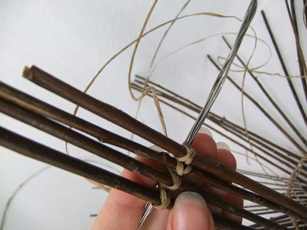 To make it easier to space out the twigs start by tying four twigs on opposite ends of the circle To make it easier to space out the twigs start by tying four twigs on opposite ends of the circle