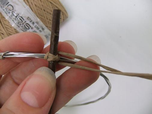 Wrap the wire around at both sides of the cross and move both ends of wire to the side