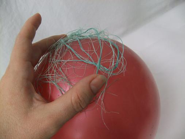 Spread the sisal in a thin layer over the balloon.