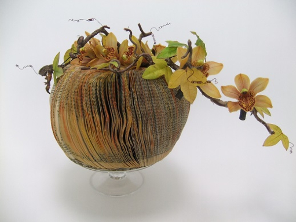 Cymbidium, hazel and passion fruit vines on a paperback book pumpkin