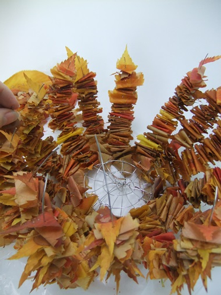 Fill up most of the wire with folded leaves.