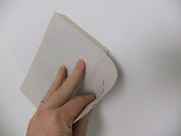 Start to break the spine of the book by bending the pages back