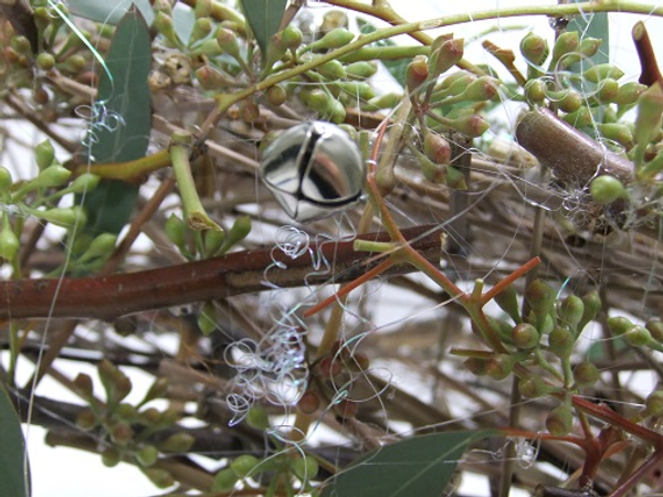 Curl tinsel to drape over the seeded eucalyptus.