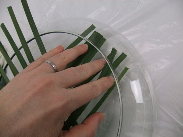Gently tuck the first side of foliage strands into the container