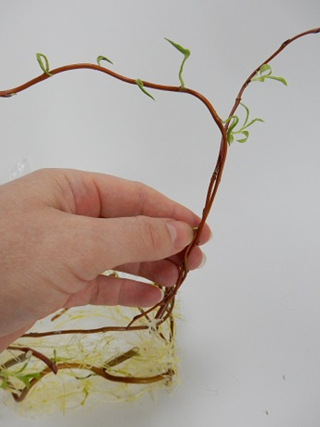 Add another stem by first weaving it into the sisal and then twisting it around the first willow stem