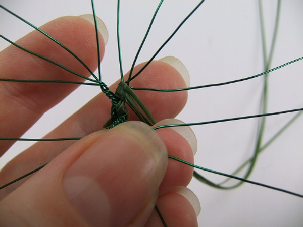 Fold the strands of grass behind the wire.