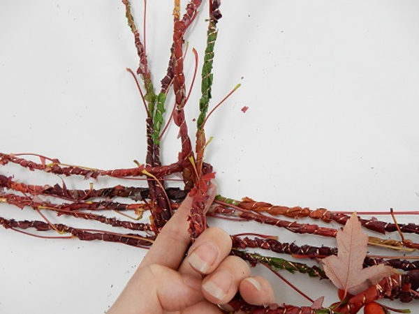 Bend the long side of the garland down to start the weave