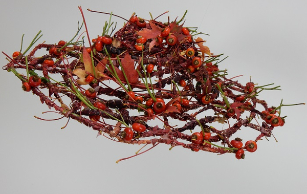 Weaving a hat from autumn leaves and rosehips with copper accents