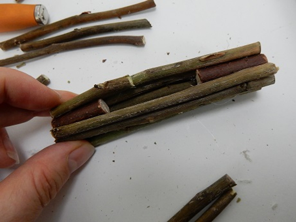 When you reach the front half of the thick twig glue shorter twigs to create a gap for the floral material. When you reach the front half of the thick twig glue shorter twigs to create a gap for the floral material.