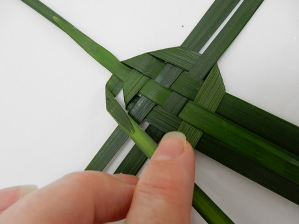 Fold it over and weave it through the three leaves in the bottom