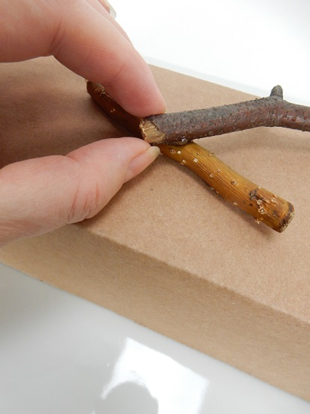 Place a small drop of hot glue on the twig and glue another twig to that