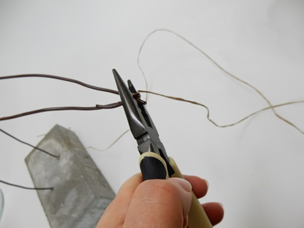 Bend the wire over the bind wire with pliers to secure it in place