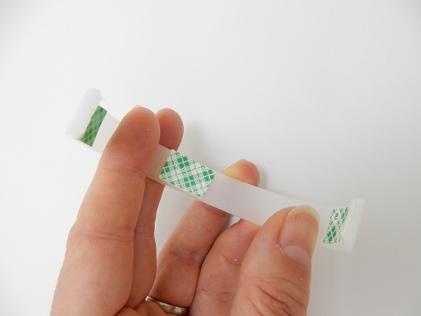 Place three sections of double sided tape in the inside of the loop Place three sections of double sided tape in the inside of the loop