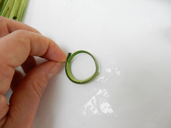 Curve the blade of grass into a ring and secure with decorative wire