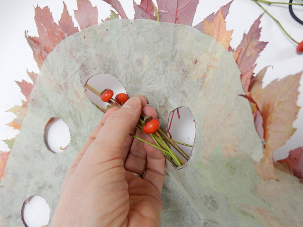 Weave the rosehip garland through the holes in the leaf disk
