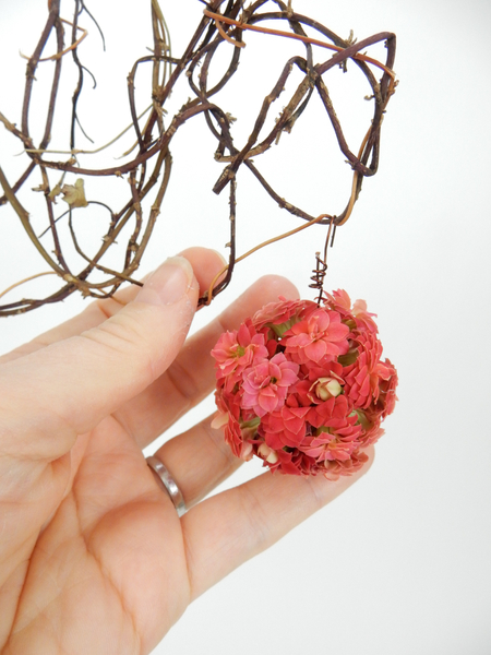 Cover the rest of the acorn with flowers and hang it in the design from the wire tendril.