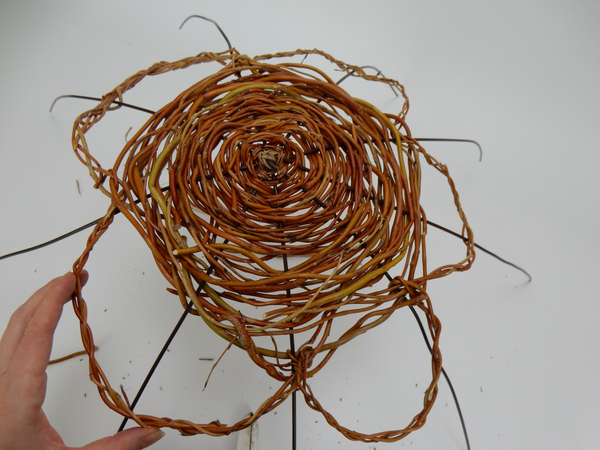 Plait three willow stems around the woven spiral to look like flower petals