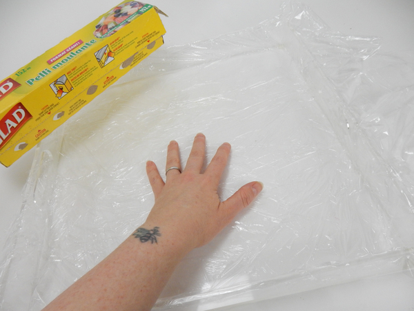 Line a deep square tray with plastic wrap