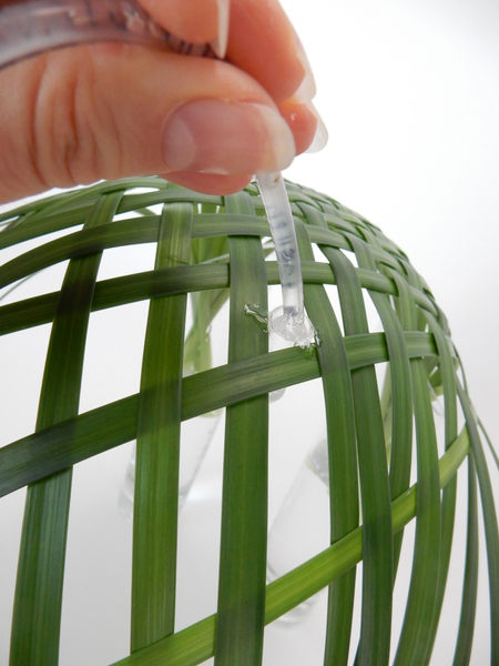 Glue in tiny drinking straw test tubes to keep the orchids hydrated