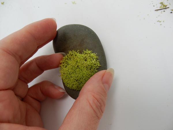Glue a snippet of moss to a decorative rock with floral glue