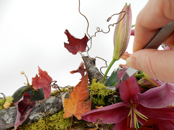 Insert the flowers in the wet foam and conceal the base with moss