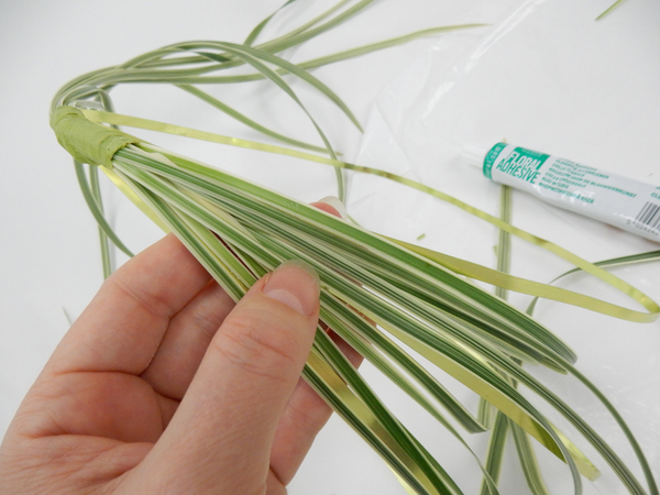 Bend the grass down to the side of the basket and secure with floral glue to the wire