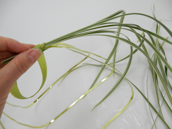 Bind a small bundle of grass to the one side of the basket handle letting the tips dangle down the side