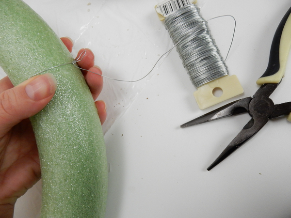 Wrap silver wire around a foam wreath frame and add a loop to make it easier to hang the wreath