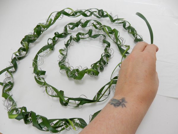 Continue to cover the wire by gently curving and coiling the grass around the spiral