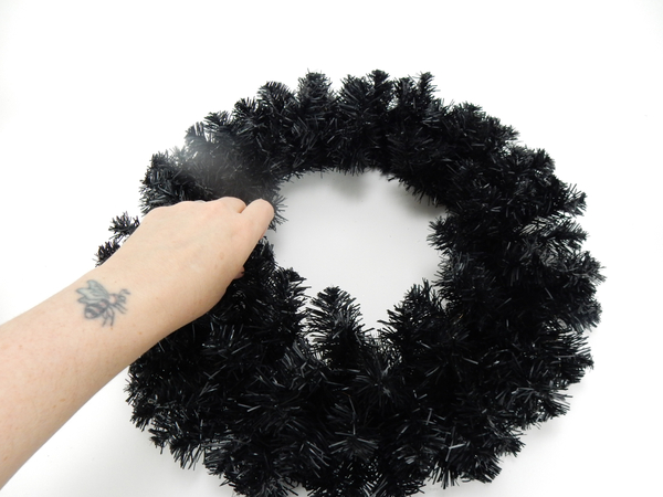 Place the artificial wreath on a flat working surface and fluff and bend all the wires to point out
