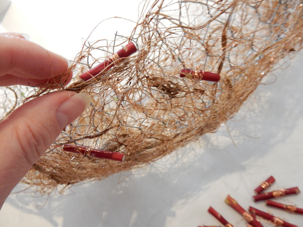 Place the copper twig garlands scattered around the armature frame