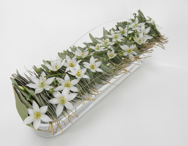 Eucomis and Eucalyptus and grass in a glass container