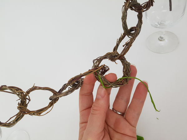 Press the stem end into a gap in the wreath
