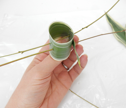 Skewer leaf rolls to support a tiny water source for fresh flowers