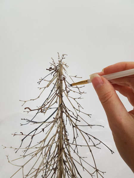Paint the delicate branches with wood glue and sprinkle with fake snow