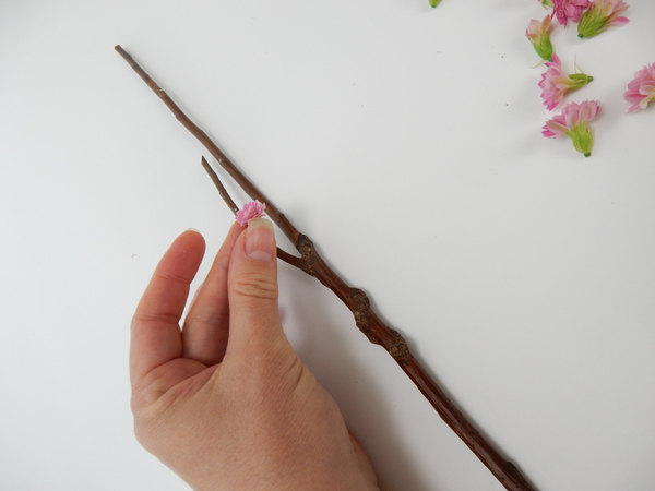 Decide on your design and glue the flowers to the wand with floral glue.