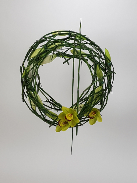 Lily, Cymbidium and wired Equisetum wreath flower arrangement