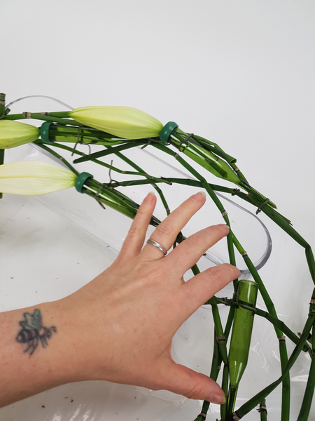 Twist the wreath so that you can fill and position the next water tube and lily