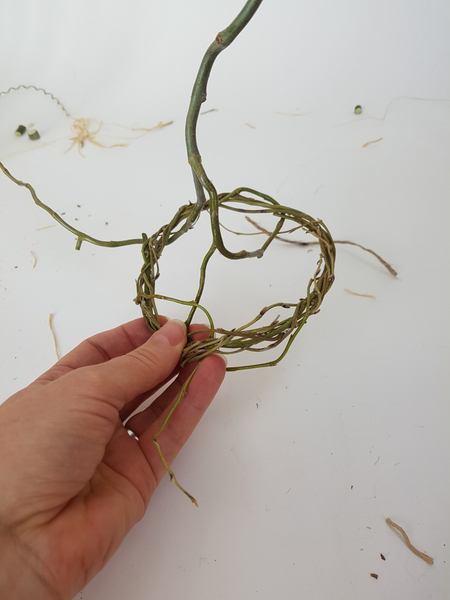 Weave a pliable willow stem with a fork in it’s twigs through the last and smallest wreath. Weave a pliable willow stem with a fork in it’s twigs through the last and smallest wreath.
